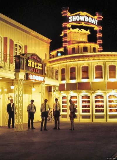 The Showboat hotel lobby entrance and riverboat facade illuminated at night in 1968, photographed in vertical format
