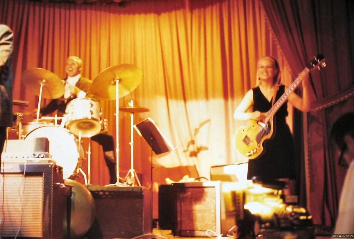 A band performing on a stage inside the Showboat in 1968, lit in warm orange stage light